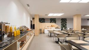 a restaurant with tables and chairs and a counter at Hotel Airiños 3* in Cangas de Morrazo