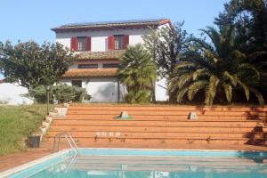 una casa e una piscina di fronte a una casa di Villa Nerone B&B a Lorenzana