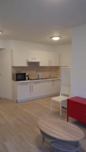 - une cuisine avec des placards blancs et une table dans une pièce dans l'établissement Central Appartment 2 bedrooms, à Bruxelles