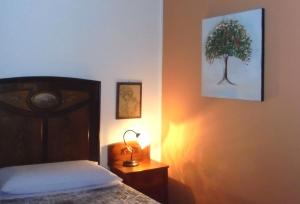 ein Schlafzimmer mit einem Bett und einem Baum an der Wand in der Unterkunft La Casa di Campagna in Reggio nell'Emilia