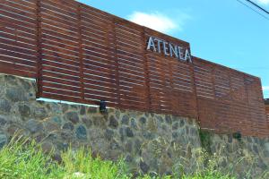 Una pared de ladrillo con un cartel encima. en Atenea en Villa Carlos Paz