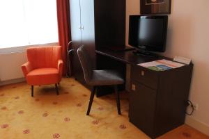 a living room with a chair and a desk at Hotel Oranjeoord in Apeldoorn