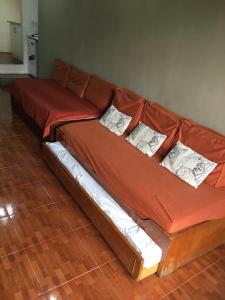 Sofá marrón con 4 almohadas en el suelo de madera en Rincón de Araus, en Colonia del Sacramento