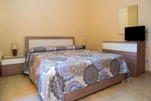 a bedroom with a bed and a flat screen tv at Casa del Melograno 40 in Roccalumera