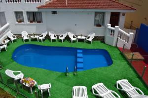 an image of a swimming pool with chairs and a table at Atenea in Villa Carlos Paz