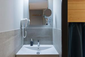a bathroom sink with a phone and a mirror at Yeah Barcelona Hostel in Barcelona