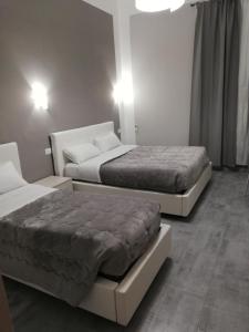 2 Betten in einem Zimmer mit 2 Schlafgelegenheiten in der Unterkunft Garden's Elide in Rom