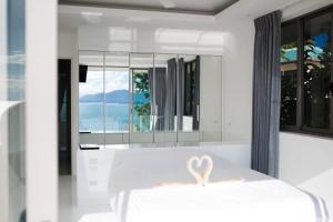 a bedroom with a white bed with a heart on it at Villa Oceane in Thong Son Beach