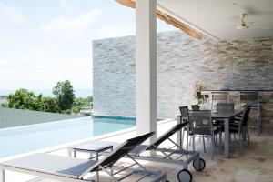un patio con mesa y sillas junto a una piscina en Villa Oceane, en Thong Son Beach