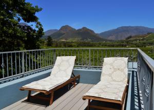 dos sillas en una terraza con montañas en el fondo en 1AA Wilhelmina Luxury Suites en Franschhoek