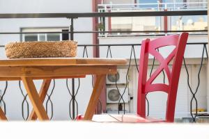 a picnic table and a red chair on a balcony at B&B A Pochi Passi in Polignano a Mare