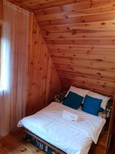 una camera con un letto su una parete in legno di LAGO BLANCO a Klusek Biały