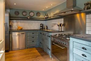 una cocina con armarios azules y electrodomésticos de acero inoxidable en Tulpenhuis Enkhuizen, en Enkhuizen