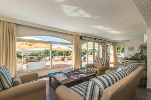 sala de estar con sofá, sillas y mesa en Hotel 3 Botti en Baja Sardinia