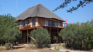 une maison au toit de chaume avec un toit de chaume dans l'établissement Baobab - NUDE - SunEden Family Naturist Resort, à Pretoria