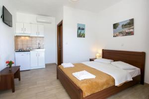 a bedroom with a large bed and a kitchen at Dolphins House in Koinyra