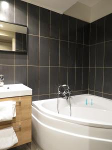 La salle de bains est pourvue d'une baignoire et d'un lavabo. dans l'établissement Hostellerie Du Royal Lieu, à Compiègne