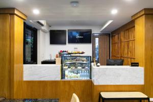 a restaurant with a counter with a refrigerator at Sukhon Hotel - SHA Plus in Bangkok
