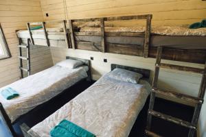 a room with three bunk beds in a room at Lauku Kūrorts in Kazdanga