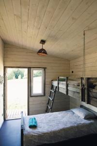 a bedroom with a bed in a wooden cabin at Lauku Kūrorts in Kazdanga