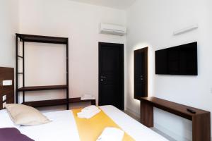a bedroom with a bed and a flat screen tv at Acate81 Lifestyle Apartment in Naples
