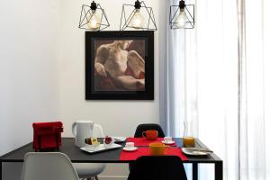 a dining room with a table and a painting on the wall at Acate81 Lifestyle Apartment in Naples