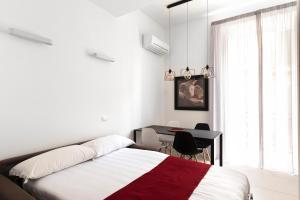 a bedroom with a bed and a desk and a window at Acate81 Lifestyle Apartment in Naples