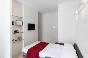 a white bedroom with a bed and shelves at Acate81 Lifestyle Apartment in Naples