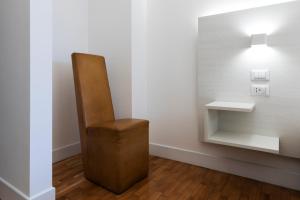 a brown chair sitting in a room with a light at Acate81 Lifestyle Apartment in Naples