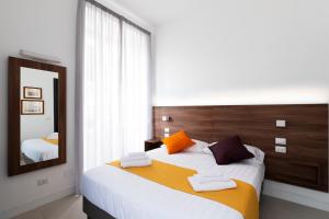 a bedroom with a large bed and a mirror at Acate81 Lifestyle Apartment in Naples
