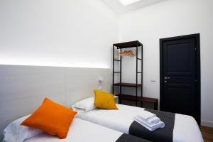 two beds with orange and white pillows in a room at Acate81 Lifestyle Apartment in Naples