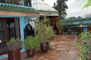 een patio met potplanten voor een huis bij Riad Lahboul in Meknès