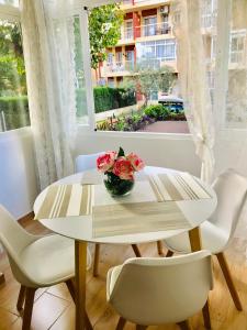 Biały stół z wazonem kwiatów w obiekcie Edifício Hercules w mieście Benalmádena