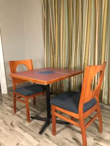 a wooden table with two chairs and a table at Bay Breeze Inn Bradenton Downtown in Bradenton
