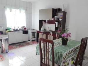 a kitchen with a table and chairs and a kitchen with a stove at Casa de Praia in Itapema