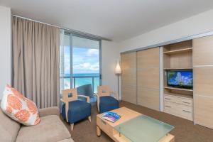 a living room with a couch and a tv at Sunny Isles ocean view 1 bedroom at Marenas Resort 20th in Miami Beach