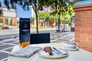 a table with a piece of cake and a cup of coffee at Senator Huelva in Huelva