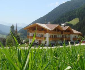 a building in the middle of a field of grass at Hotel Gsieserhof in Valle Di Casies