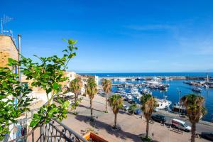 a marina with boats in the water and palm trees at Solemar Sicilia - Casa Porto Bagnera in Santa Flavia