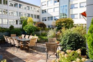 une terrasse avec une table et des chaises devant un bâtiment dans l'établissement Kronenhotel, à Stuttgart