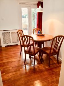 a dining room with a table and chairs and a fan at Tapestry Apartment in London