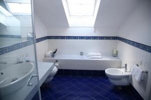 a bathroom with a tub and a toilet and a sink at Palazzetto Florio 1810 in Santa Maria di Castellabate +23 photos