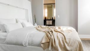 ein weißes Bett mit einer Decke darüber in der Unterkunft Hotel Gerbermühle in Frankfurt am Main