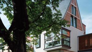 a house with a tree in front of it at Hotel Gerbermühle in Frankfurt