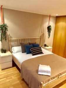 a bedroom with a large bed with two potted plants at Oupen De Dor - Virgenes El Pilar in Zaragoza