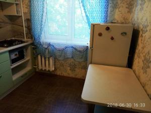 ニジニ・タギルにあるАпартаменты на ул. Октябрьской революции,32の小さなキッチン(冷蔵庫付)、窓が備わります。