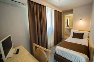 a hotel room with a bed and a desk and a television at Hotel Soleluna in Piano di Sorrento
