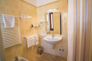 a bathroom with a sink and a toilet and a mirror at Hotel Soleluna in Piano di Sorrento