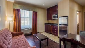 a living room with a couch and a kitchen at Best Western Plus Bowmanville in Bowmanville