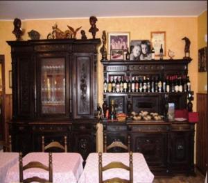 una sala da pranzo con un grande mobile in legno con bar di Hotel La Solitaria a Carlazzo